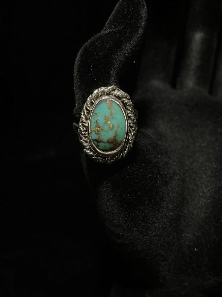 Turquoise ring — front view of the oval stone webbed with golden-brown matrix, rope bezel, on black velvet