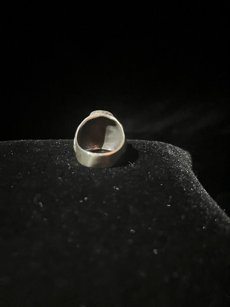 Turquoise ring — back view of the wide sterling silver band, smooth inside the shank, standing on black velvet