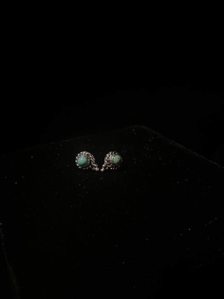 Turquoise stud earrings — a rope and bottom-bead pair close on black velvet, green stones showing