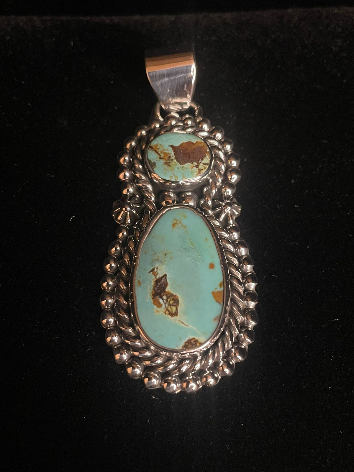 Two-stone turquoise pendant — straight front view, pale aqua stones with brown matrix, rope and bead frame