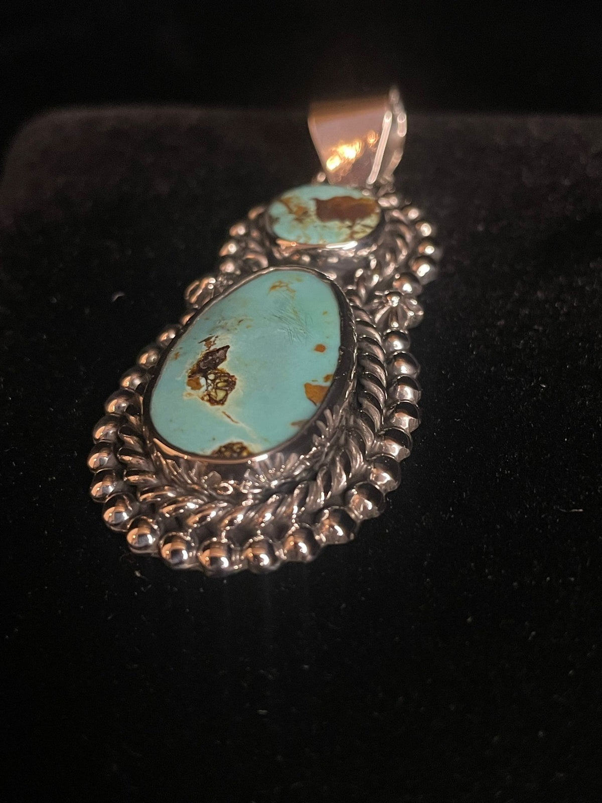 Two-stone turquoise pendant — angled front view, pale aqua stones with brown matrix in rope and bead silver