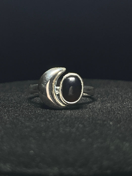 Crescent moon ring — black obsidian oval beside a polished sterling silver crescent moon on black