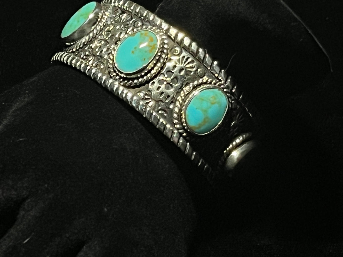 Turquoise cuff — oval blue-green turquoise stones with golden matrix in rope bezels, close detail on black