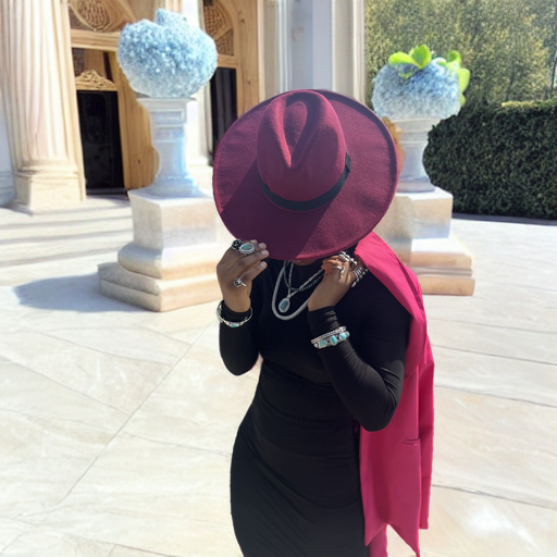 Turquoise cuff — worn on a wrist in a full-length outdoor portrait with a deep pink hat, stone plaza setting